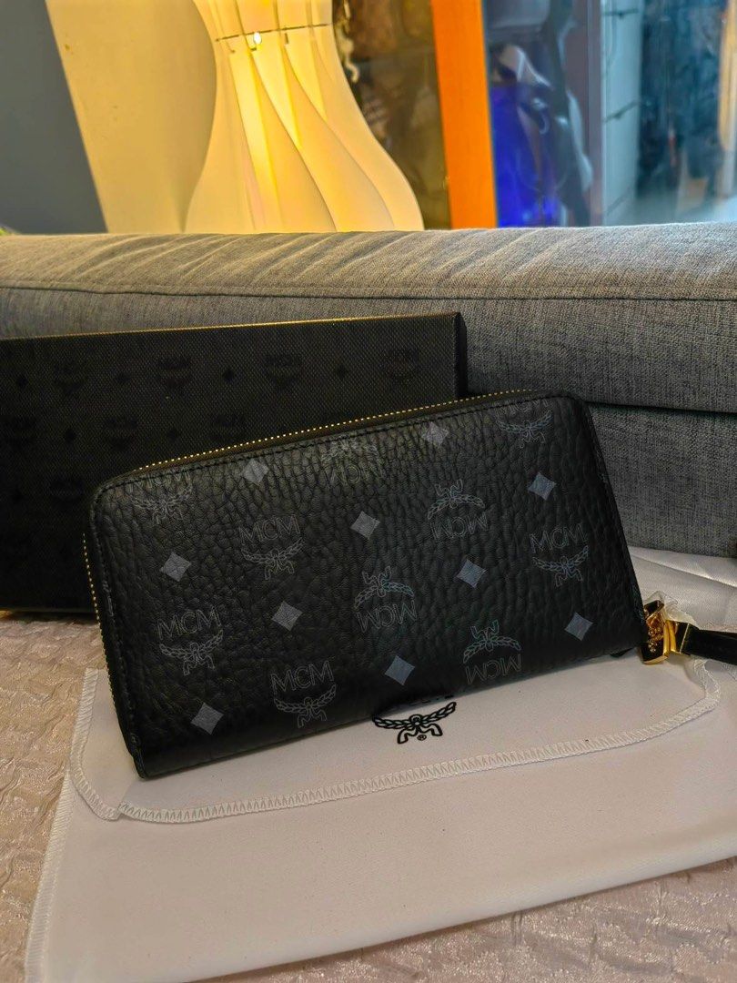MCM Zip Around Wallet (Category: Luxury Bags & Wallets) located in Cebu City. Submitted by day.98 (Listing ID 1423119067, Image 3). Description: - Selected from japan surplus - Black exterior with MCM logo pattern - Gold-tone hardware - Multiple card slots and compartments - Includes dust bag and box - MCM logo on zipper pull - Comes with warranty card.