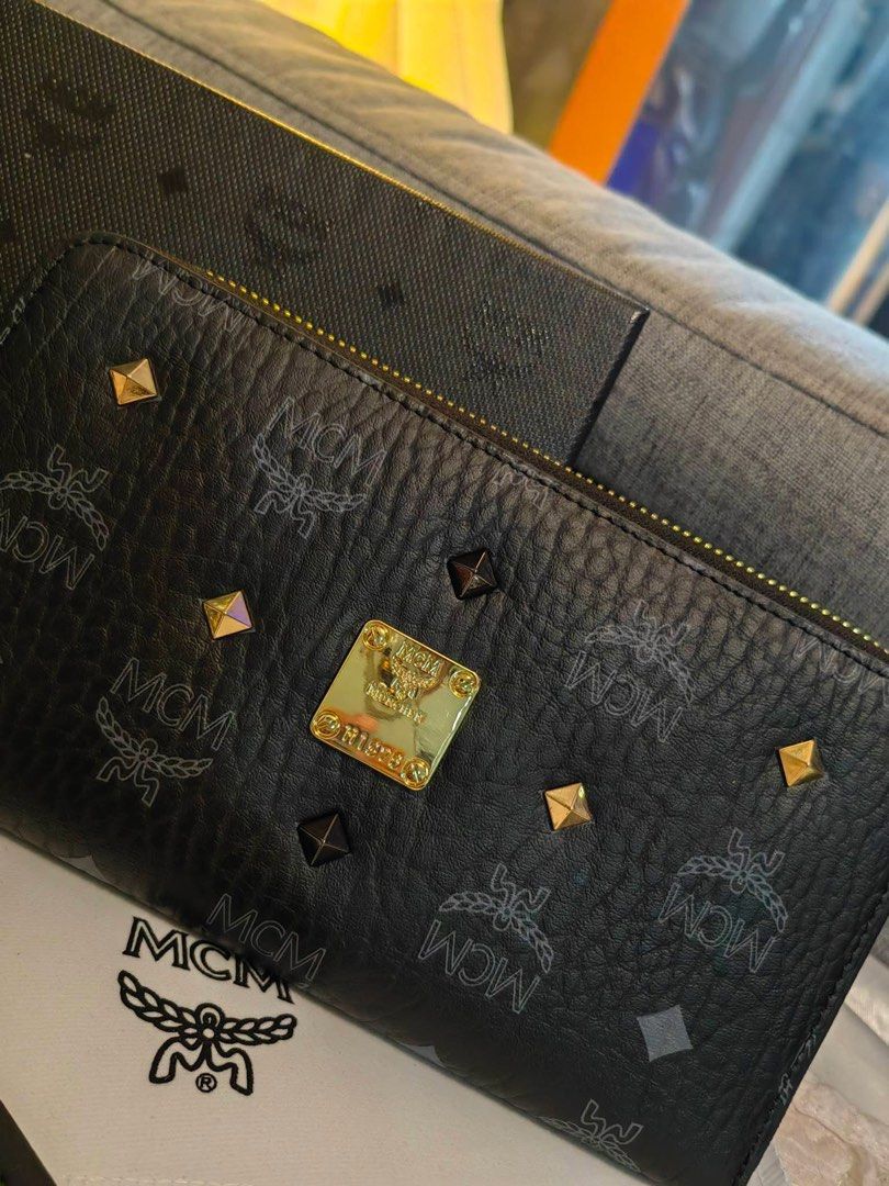 MCM Zip Around Wallet (Category: Luxury Bags & Wallets) located in Cebu City. Submitted by day.98 (Listing ID 1423119067, Image 2). Description: - Selected from japan surplus - Black exterior with MCM logo pattern - Gold-tone hardware - Multiple card slots and compartments - Includes dust bag and box - MCM logo on zipper pull - Comes with warranty card.