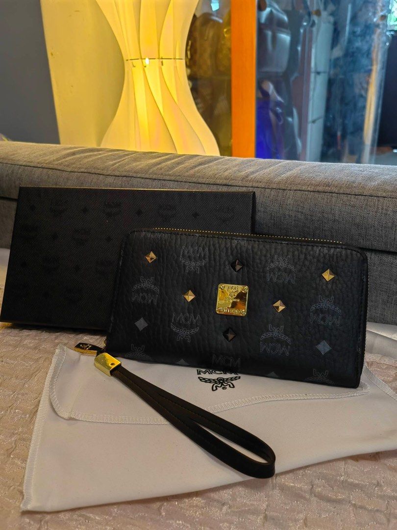 MCM Zip Around Wallet (Category: Luxury Bags & Wallets) located in Cebu City. Submitted by day.98 (Listing ID 1423119067, Image 1). Description: - Selected from japan surplus - Black exterior with MCM logo pattern - Gold-tone hardware - Multiple card slots and compartments - Includes dust bag and box - MCM logo on zipper pull - Comes with warranty card.
