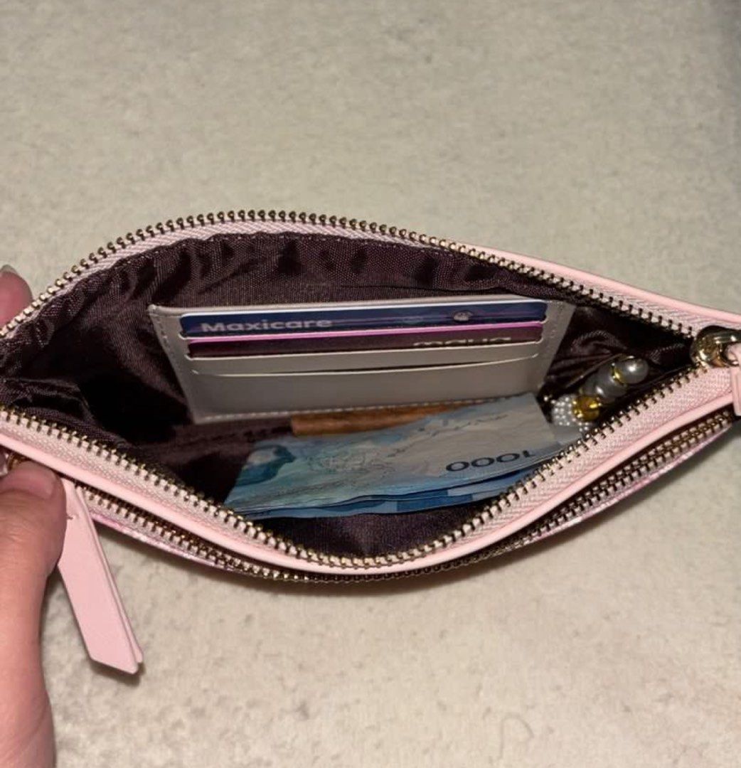 Mikana Wristlet (Koji Pink) (Category: Clutches) located in Silang. Submitted by declutterswuni (Listing ID 1423150655, Image 2). Description: - Mikana pink clutch - Wrist strap included - Secure zipper closure - Interior with multiple compartments - Includes a card holder - Textured front design - Smooth back - Ideal for cards, cash, and keys.