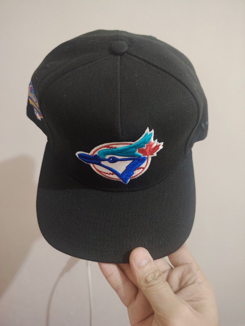 New Era Toronto Blue Jays Cap (Category: Caps & Hats) located in Manila. Submitted by kramyer24861759 (Listing ID 1423081769, Image 2). Description: Black New Era cap featuring the Toronto Blue Jays logo on the front. The cap has a flat brim and a gray underbrim. The New Era logo is visible on the side. The cap has a structured fit..