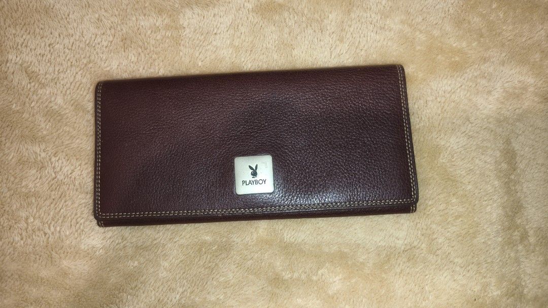 Playboy Brown Leather Wallet (Category: Wallets & Card holders) located in Tanza. Submitted by declutterolshoppe (Listing ID 1423168183, Image 1). Description: - Playboy brown leather wallet - Multiple card slots - Compartments for bills and essentials - Snap closure - Playboy logo on front and inside - Visible stitching - Classic and functional design.