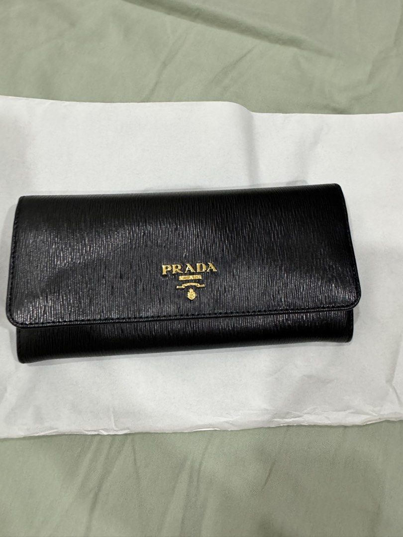 Prada Vitello Move Leather Wallet (Category: Luxury Bags & Wallets) located in Quezon City. Submitted by declutteringrobb (Listing ID 1423203336, Image 1). Description: - Authentic Prada wallet - Black Vitello Move leather - Gold-tone Prada logo - Detachable card holder included - Multiple compartments and zippered pocket - Comes with original box, authenticity and cards - Leather and fabric interior - Stored and never used - RFS: wrong size, too