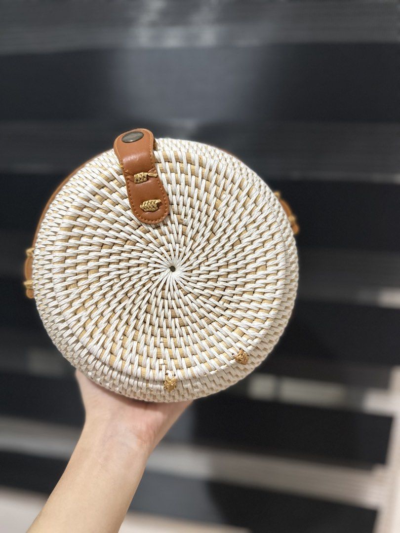 Round Woven Rattan Bag with Leather Strap (Category: Cross-body Bags) located in Carmona. Submitted by havalook (Listing ID 1423182251, Image 2). Description: - Round rattan bag - White finish - Brown leather strap - Brown leather closure - Stylish accessory.