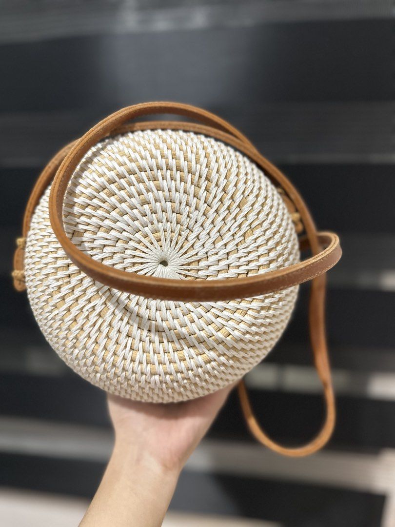 Round Woven Rattan Bag with Leather Strap (Category: Cross-body Bags) located in Carmona. Submitted by havalook (Listing ID 1423182251, Image 3). Description: - Round rattan bag - White finish - Brown leather strap - Brown leather closure - Stylish accessory.