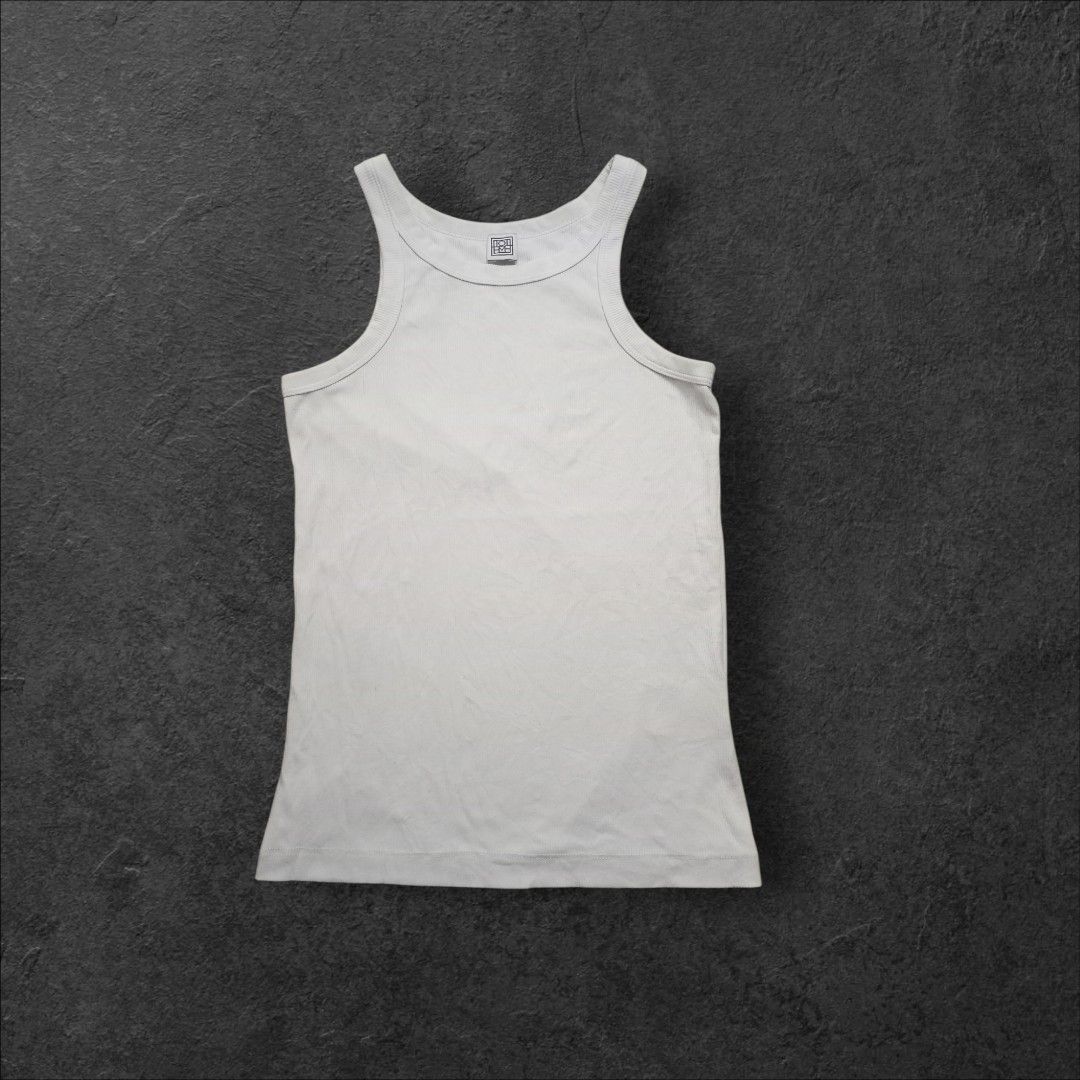 Toteme Studio Ribbed Tank Top (Category: Sleeveless) located in Alaminos. Submitted by thriftpill0302 (Listing ID 1423134413, Image 1). Description: - Toteme Studio white ribbed tank top - Excellent condition (Still presentable) - Width: 13½ can stretch up to 17 - Length: 22½ - Actual color: White - Color may appear lighter or darker due to lighting.