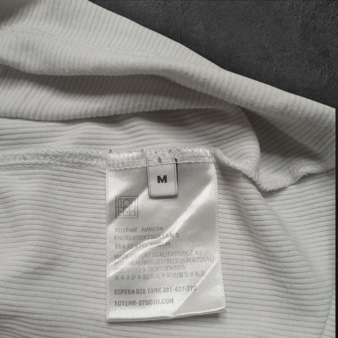 Toteme Studio Ribbed Tank Top (Category: Sleeveless) located in Alaminos. Submitted by thriftpill0302 (Listing ID 1423134413, Image 3). Description: - Toteme Studio white ribbed tank top - Excellent condition (Still presentable) - Width: 13½ can stretch up to 17 - Length: 22½ - Actual color: White - Color may appear lighter or darker due to lighting.