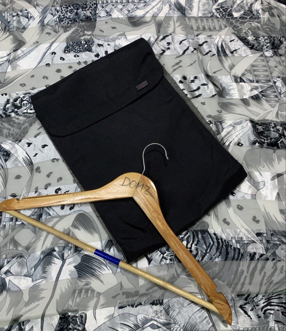 Tumi Laptop Sleeve (Category: Laptop Bags & Sleeves) located in Polomolok. Submitted by domingthriftclothes (Listing ID 1423124391, Image 2). Description: - Black Tumi laptop sleeve - Main compartment and front pocket - Interior with multiple compartments - Made of durable, textured material - Tumi logo visible - Includes a wooden hanger.