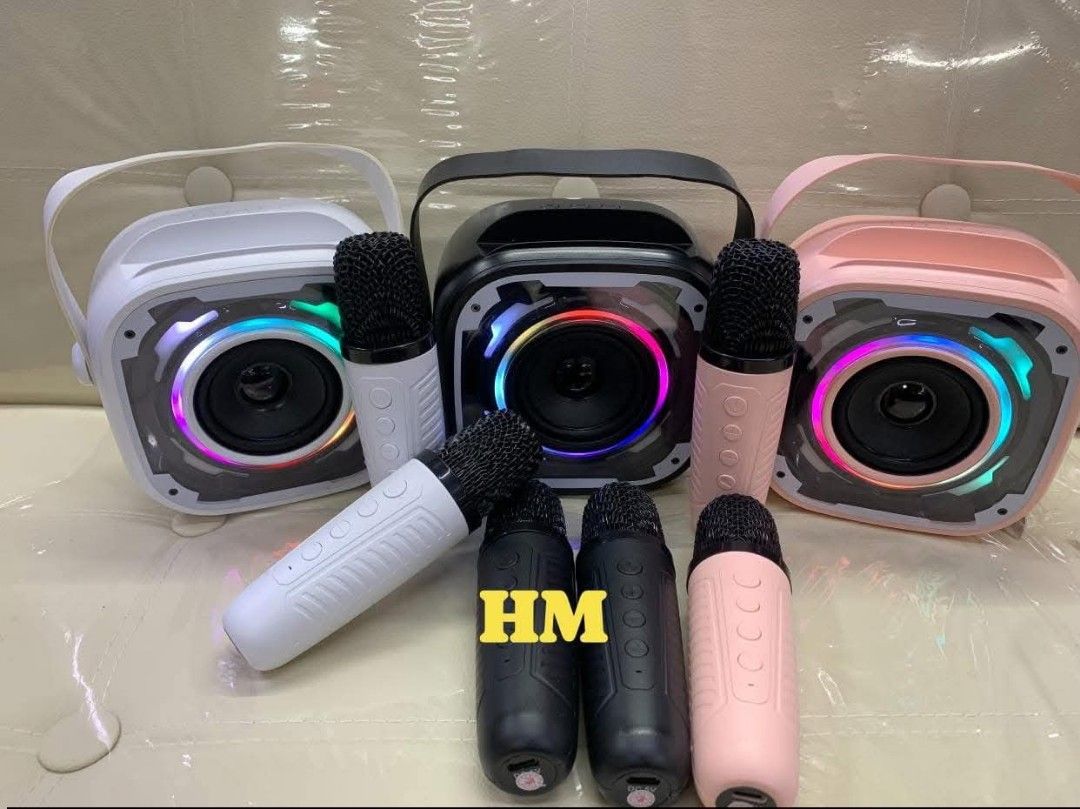 V11 Bluetooth Speaker w/dual mic (Category: Soundbars, Speakers & Amplifiers) located in Manila. Submitted by jelai.cybyb (Listing ID 1423124172, Image 2). Description: Portable karaoke speaker with built-in lighting effects. Includes two wireless microphones and a charging cable. Available in white, black, and pink. Features a handle for easy carrying. The speaker has a clear, circular speaker and control buttons on the microphone..