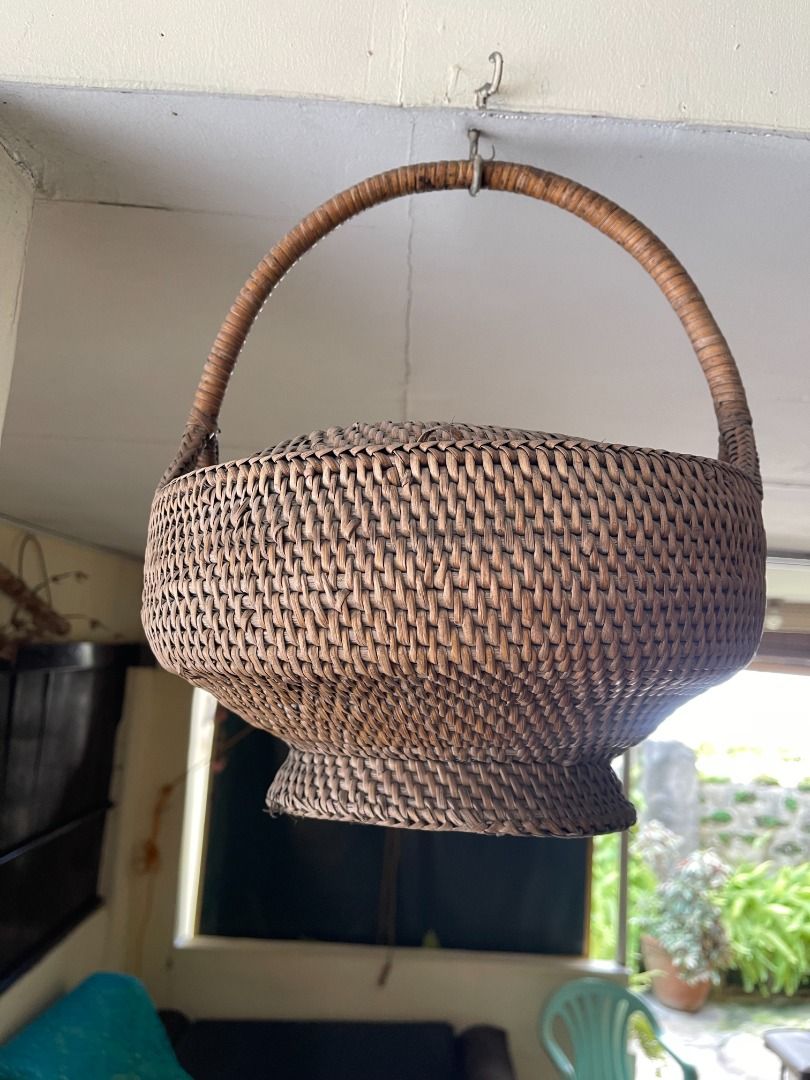 1960s Wicker Basket | Vintage (Category: Storage Boxes & Baskets) located in Quezon City. Submitted by reallyrealreal (Listing ID 1423322179, Image 1). Description: Original Price: 1000 Bought in the 1960s With a small hole at the edge of the cover Diameter: 32 Height: 38 SKQCET0041 - Vintage woven basket - Features a handle and lid - Round shape with woven design - Made of natural materials - Unique shape: wider base, narrower top.