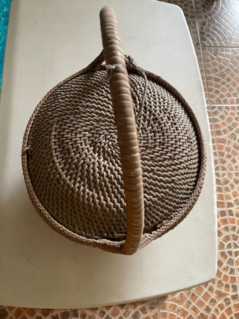1960s Wicker Basket | Vintage (Category: Storage Boxes & Baskets) located in Quezon City. Submitted by reallyrealreal (Listing ID 1423322179, Image 2). Description: Original Price: 1000 Bought in the 1960s With a small hole at the edge of the cover Diameter: 32 Height: 38 SKQCET0041 - Vintage woven basket - Features a handle and lid - Round shape with woven design - Made of natural materials - Unique shape: wider base, narrower top.