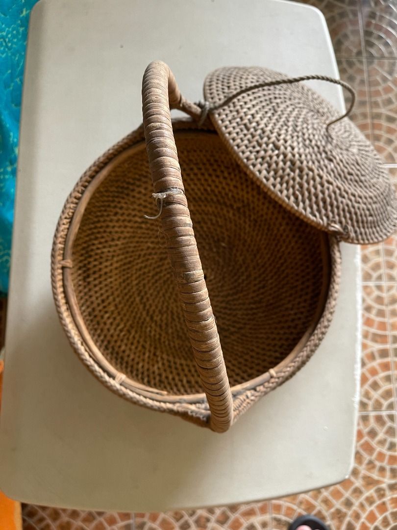 1960s Wicker Basket | Vintage (Category: Storage Boxes & Baskets) located in Quezon City. Submitted by reallyrealreal (Listing ID 1423322179, Image 3). Description: Original Price: 1000 Bought in the 1960s With a small hole at the edge of the cover Diameter: 32 Height: 38 SKQCET0041 - Vintage woven basket - Features a handle and lid - Round shape with woven design - Made of natural materials - Unique shape: wider base, narrower top.
