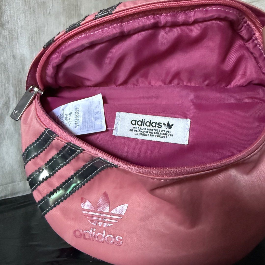 Adidas Pink Waist Bag (Category: Cross-body Bags) located in Dagupan City. Submitted by hangoverph (Listing ID 1423315168, Image 3). Description: - Pink Adidas waist bag - Iconic three stripes design - Main compartment with zipper closure - Adjustable strap - Adidas logo on the front - Lined with matching pink fabric - Ideal for carrying essentials - Used few times - Brand: Adidas - RFS: decluttering.