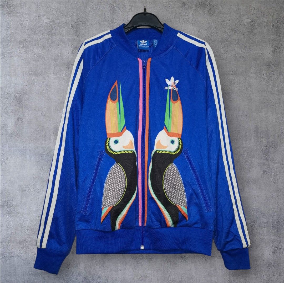 Adidas Supergirl Toucan Jacket (Category: Coats, Jackets and Outerwear) located in Manila. Submitted by eagerbeaverph (Listing ID 1423382302, Image 2). Description: Adidas x supergirl farm rio track jacket rare L 24.5 W 18 Adidas Originals Supergirl Farm Rio Track Jacket. Collaboration: FARM Rio (The FARM Company) Design: Twin toucan bird design inspired by Tijuca Island, featuring a baseball-style collar and rubber-print Trefoil logo .