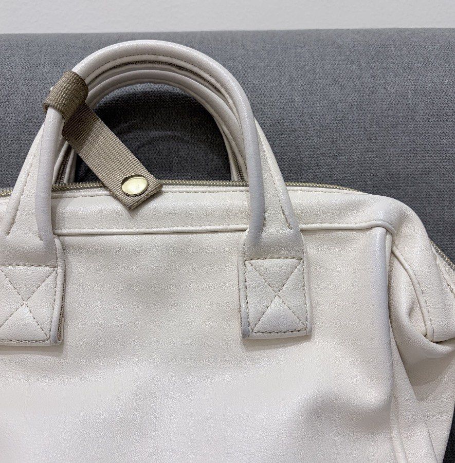 Anello 2-Way Boston Bag (Category: Cross-body Bags) located in San Juan City. Submitted by decluttzi (Listing ID 1423262710, Image 3). Description: - Cream-colored Anello Boston bag - Top handle and detachable shoulder strap - Front zippered pocket - Main compartment with multiple interior pockets - Gold-toned hardware - Brand tag on the front.