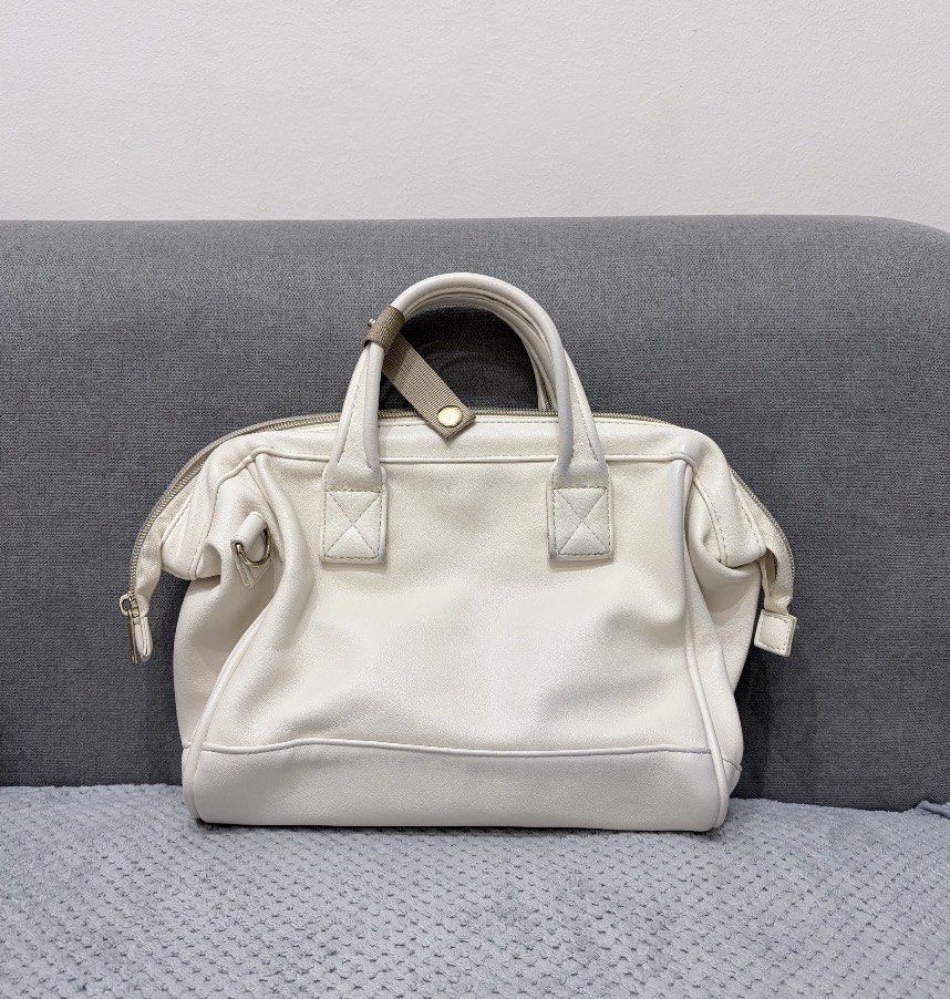 Anello 2-Way Boston Bag (Category: Cross-body Bags) located in San Juan City. Submitted by decluttzi (Listing ID 1423262710, Image 2). Description: - Cream-colored Anello Boston bag - Top handle and detachable shoulder strap - Front zippered pocket - Main compartment with multiple interior pockets - Gold-toned hardware - Brand tag on the front.