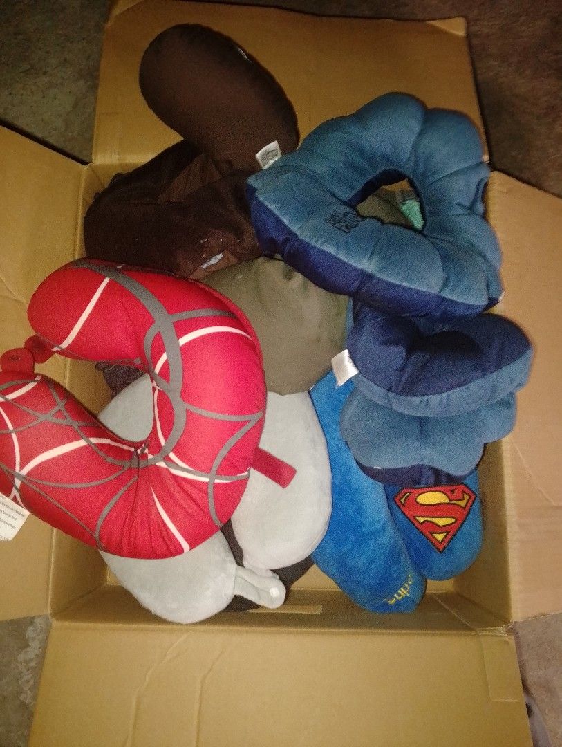 Assorted Travel Neck Pillows (Category: Travel Essentials & Accessories) located in Makati City. Submitted by meghantherobot (Listing ID 1423327974, Image 1). Description: Collection of travel neck pillows in various colors and designs. Includes a Spider-Man pillow, a Superman pillow, and other solid-colored and patterned pillows. These pillows appear to be made of soft, plush materials, ideal for travel comfort. They are stored in a cardboard bo