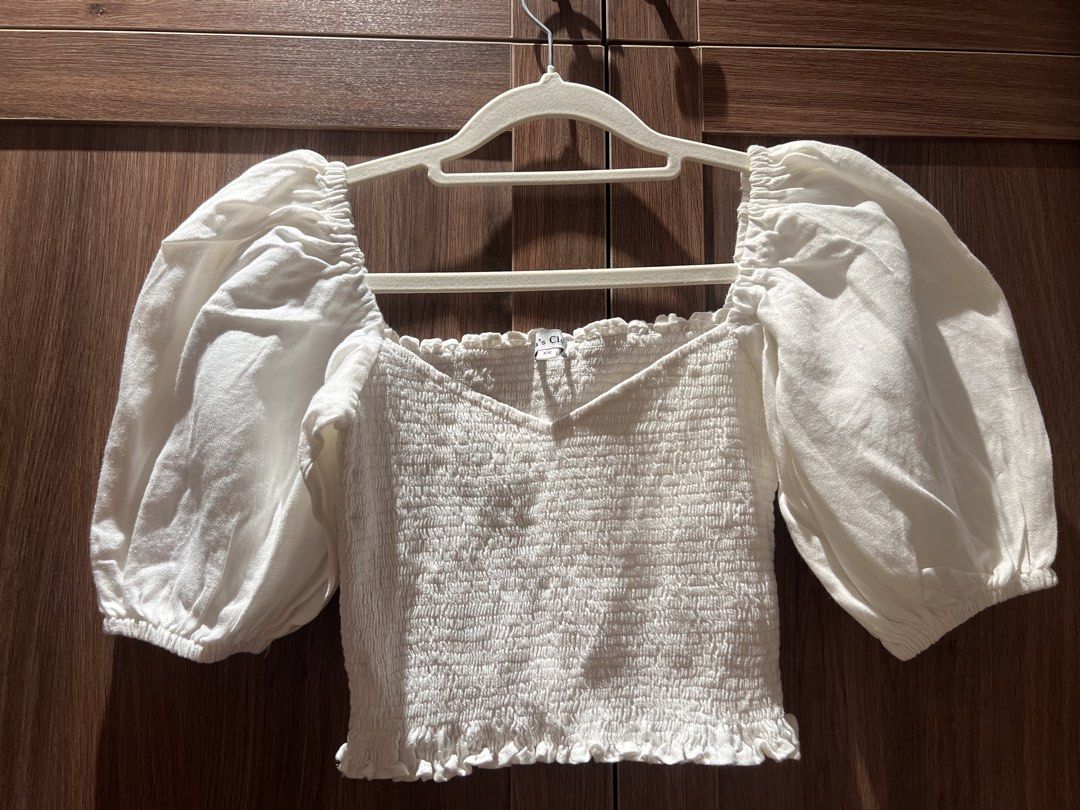 Bea's Closet White Reign Top XS (Category: Blouses) located in Quezon City. Submitted by _dolfin (Listing ID 1423356437, Image 2). Description: - Bea's Closet white Reign top - Size: XS Features: - Puff sleeves - Sweetheart neckline - Smocked bodice - Cropped length - Perfect for casual wear.