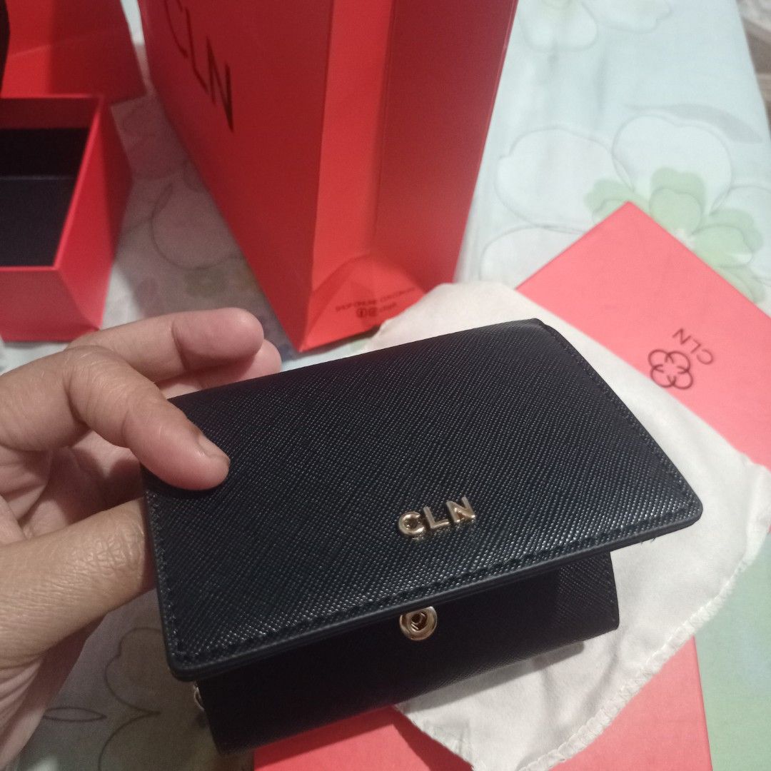 CLN Black Wallet (Category: Wallets & Card holders) located in Manila. Submitted by grandcat-96b481 (Listing ID 1423287570, Image 2). Description: Black CLN wallet with gold-colored zipper and logo. Features multiple compartments for cards and cash. Includes original box and dust bag. Compact and stylish design, perfect for everyday use. The wallet has a snap closure and a coin compartment..