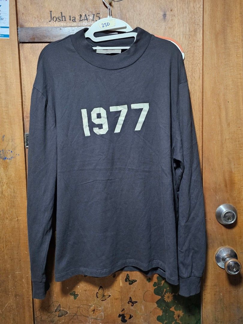 Essentials 1977 Long Sleeve Shirt (Category: Tshirts & Polo Shirts ) located in San Jose del Monte. Submitted by levanthrift (Listing ID 1423404284, Image 1). Description: 23x28 Essentials long sleeve shirt in black. Features the number "1977" printed on the front. The shirt has a small Essentials logo patch on the back of the neck. Made of 100% cotton. Size S. Made in China..
