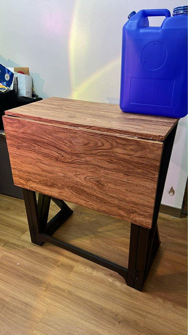 Foldable Table with Stools (Category: Tables & Sets) located in Quezon City. Submitted by sell4less123 (Listing ID 1423372655, Image 1). Description: - Foldable table for space-saving storage. - Wooden tabletop with a dark metal frame. - Includes two matching stools. - Ideal for small apartments or breakfast nooks. - Table folds away when not in use. 80x80in.