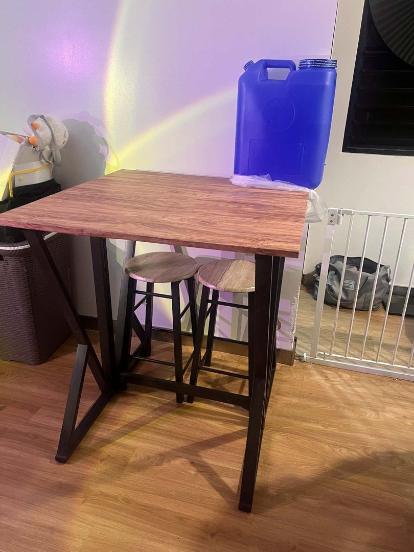 Foldable Table with Stools (Category: Tables & Sets) located in Quezon City. Submitted by sell4less123 (Listing ID 1423372655, Image 3). Description: - Foldable table for space-saving storage. - Wooden tabletop with a dark metal frame. - Includes two matching stools. - Ideal for small apartments or breakfast nooks. - Table folds away when not in use. 80x80in.