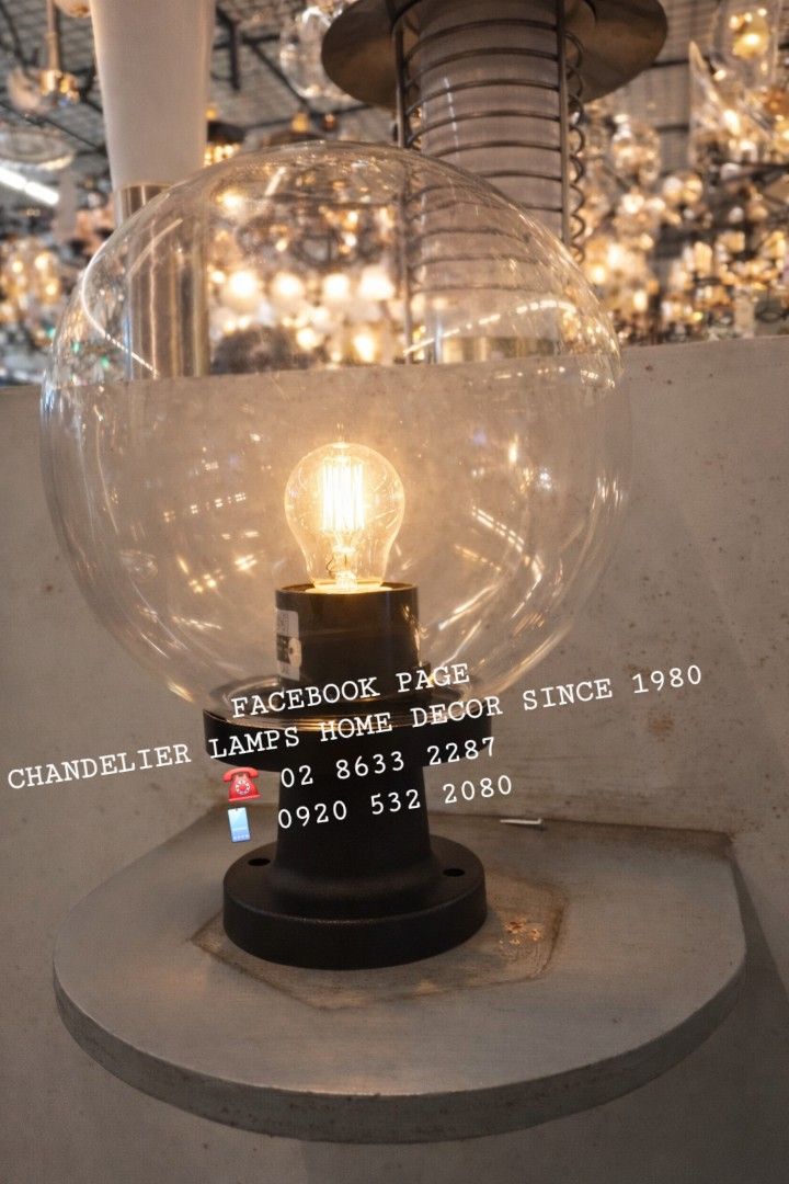 Globe post lamp with Edison Bulb (Category: Lighting) located in Antipolo. Submitted by homelightingtrading (Listing ID 1423270857, Image 1). Description: Stylish table lamp featuring a clear globe shade and a vintage Edison bulb. The lamp has a black base and sits on a concrete-like platform. Perfect for adding a touch of industrial chic to any space. The lamp is designed for home decor and provides warm, inviting light..