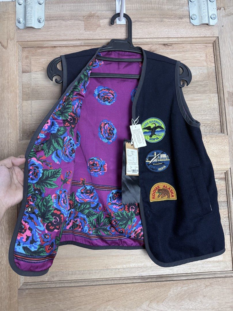 Go 2 Hollywood Patchwork Vest (Category: Vests) located in San Pablo. Submitted by zzz.archvs (Listing ID 1423428333, Image 3). Description: - Go 2 Hollywood vest - Size 130 - Navy exterior with patches - Floral patterned lining (purple base) - Button-up front - Gray trim - Two pockets - Fabric: Wool, acrylic, polyester.