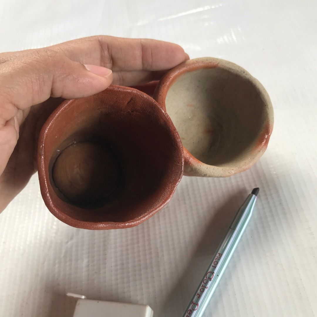 Handmade Pottery Cups Set #4360 (Category: Coffee & Tea Tableware) located in Malabon City. Submitted by mldg.surplus (Listing ID 1423366257, Image 3). Description: Set of two handmade pottery cups. One cup measures 7x8 cm, and the other measures 7x4 cm. Both cups feature a unique reddish-brown and beige color scheme. The larger cup has a textured exterior, while the smaller cup has a smooth finish. Perfect for adding a touch of artistry to your 