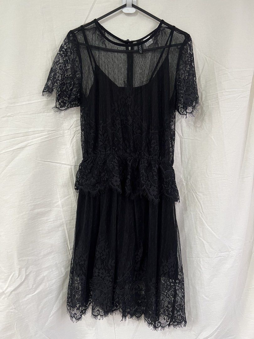 H&M Divided Black Lace Dress (Category: Dresses) located in Cainta. Submitted by thrift.reset (Listing ID 1423275513, Image 1). Description: Black lace dress from H&M Divided. Features a layered design with a sheer lace overlay and a solid black slip underneath. The dress has short sleeves and a detailed lace hem. It has a button closure at the back. Size is EUR 32, US 2, CN 155/76A, and MX 2. Last price posted..