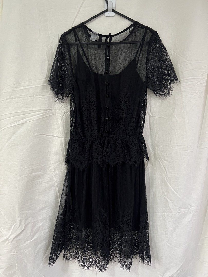 H&M Divided Black Lace Dress (Category: Dresses) located in Cainta. Submitted by thrift.reset (Listing ID 1423275513, Image 2). Description: Black lace dress from H&M Divided. Features a layered design with a sheer lace overlay and a solid black slip underneath. The dress has short sleeves and a detailed lace hem. It has a button closure at the back. Size is EUR 32, US 2, CN 155/76A, and MX 2. Last price posted..