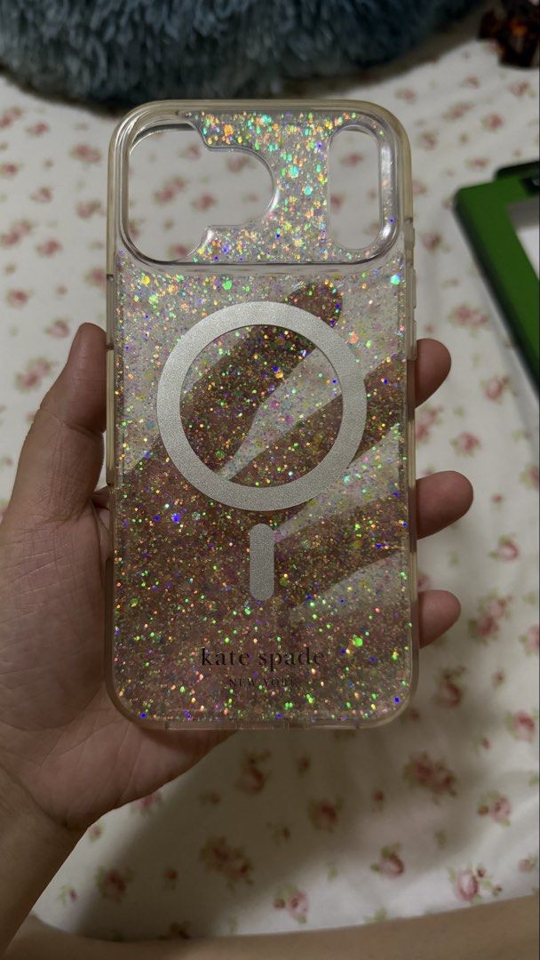 Kate Spade Iphone 17 Pro Max Case (Category: Cases & Sleeves) located in Manila. Submitted by saydeclutter (Listing ID 1423403636, Image 3). Description: Authentic Kate Spade New York clear glitter case with built-in MagSafe ring 🤍 Super ganda ng holographic glitter ang lakas maka-sparkle sa light ✨ 💎 Clear glitter design with white MagSafe ring – May slight yellowing na on the sides (normal for clear cases) – No cracks – Still sturdy and fully