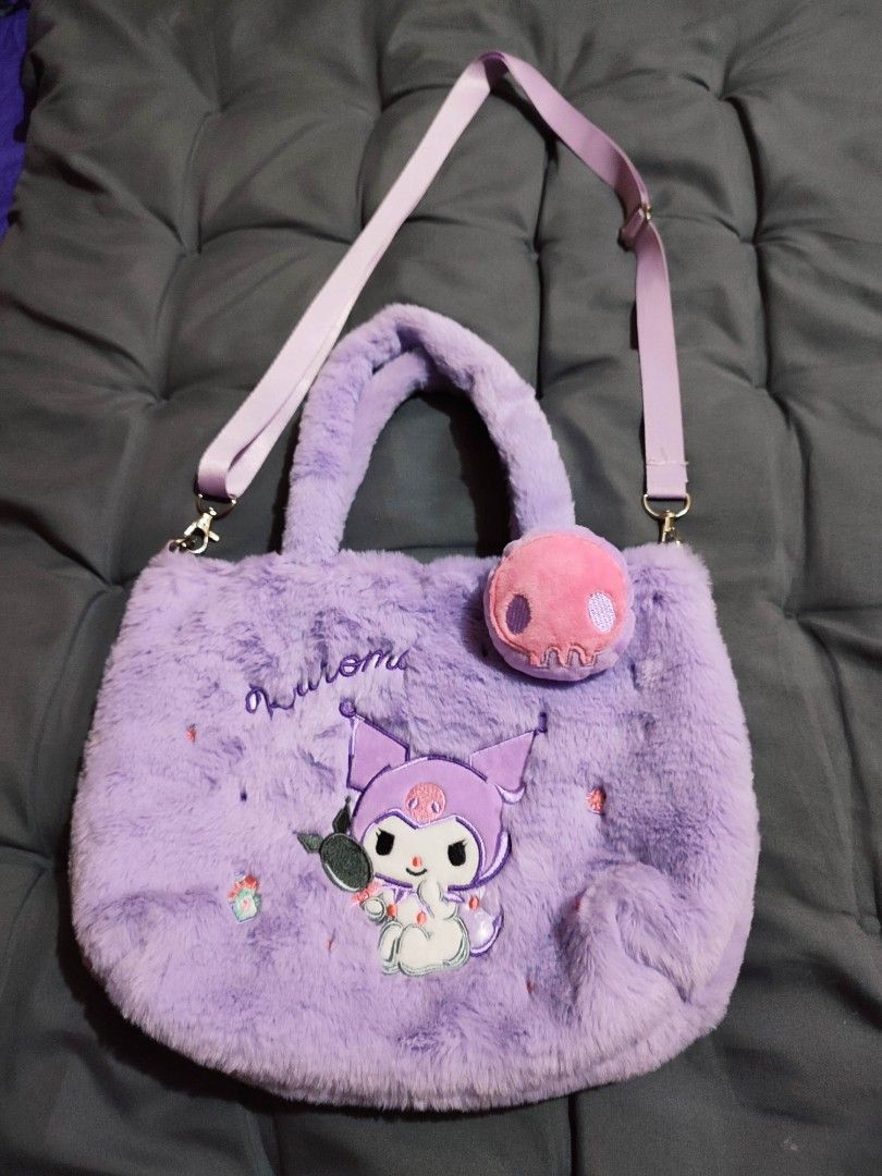 Kuromi Plush Tote Bag with Shoulder Strap (Category: Tote Bags) located in Mangaldan. Submitted by michelle_2004 (Listing ID 1423370938, Image 1). Description: Adorable tote bag features a fluffy purple exterior with a Kuromi design. It includes a detachable shoulder strap and a small skull-shaped accessory. The bag has a top handle and a snap closure. The interior is lined with a matching purple fabric. Perfect for carrying your essentials with 