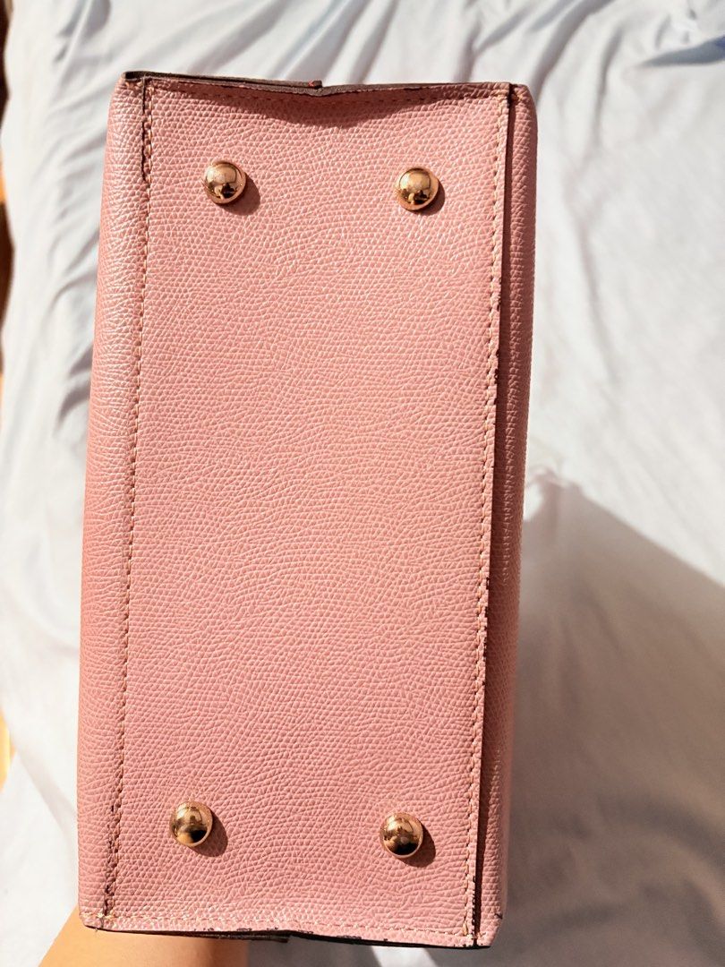 Le Junev Pink Handbag with Sling Strap (Category: Luxury Bags & Wallets) located in Marikina City. Submitted by savedbygracephb (Listing ID 1423423572, Image 2). Description: Pink Le Junev handbag with top handles and a detachable sling strap. Features a zip closure and gold-tone hardware. The bag has a textured exterior and protective feet on the bottom. Includes a brand tag inside. Color muted pink No issues.