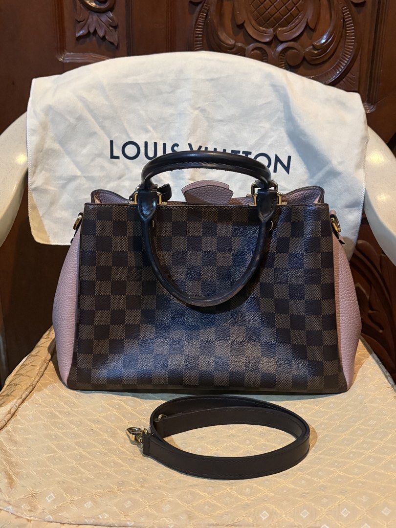 Louis Vuitton Damier Brittany Handbag (Category: Luxury Bags & Wallets) located in Marikina City. Submitted by ellemss (Listing ID 1423401806, Image 1). Description: Authentic Louis Vuitton handbag in Damier Ebene canvas. Features a brown and pink color scheme with a top handle and a detachable shoulder strap. Includes a dust bag. The interior has a zippered pocket. Gold-tone hardware is visible on the bag. The bag has protective feet on the bott