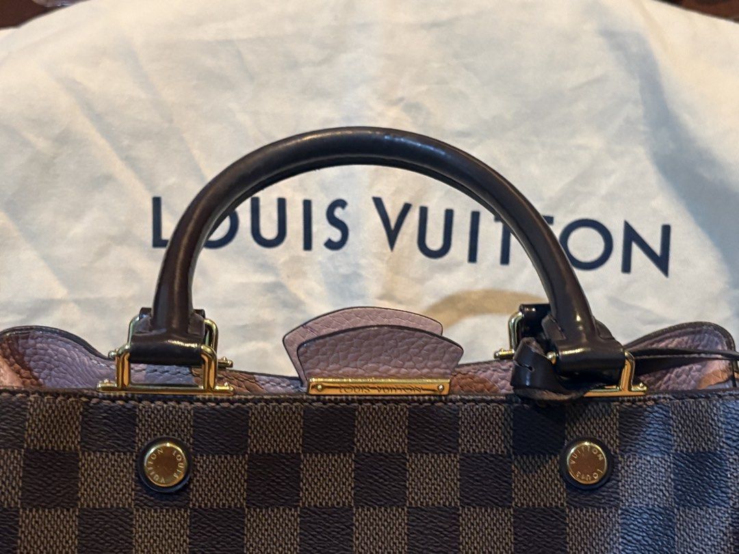 Louis Vuitton Damier Brittany Handbag (Category: Luxury Bags & Wallets) located in Marikina City. Submitted by ellemss (Listing ID 1423401806, Image 3). Description: Authentic Louis Vuitton handbag in Damier Ebene canvas. Features a brown and pink color scheme with a top handle and a detachable shoulder strap. Includes a dust bag. The interior has a zippered pocket. Gold-tone hardware is visible on the bag. The bag has protective feet on the bott