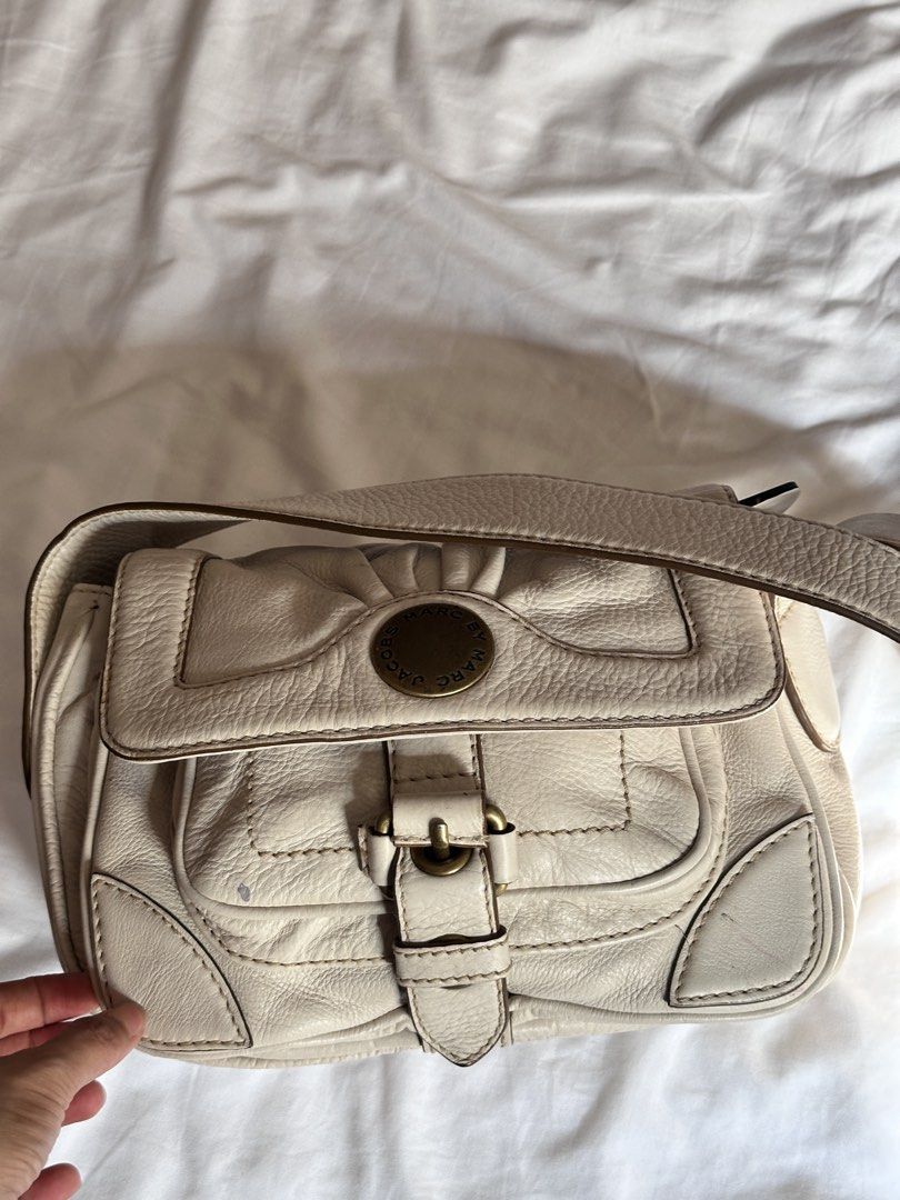 Marc by Marc Jacobs Cream Shoulder Bag (Category: Luxury Bags & Wallets) located in Tabuk. Submitted by classicseconds (Listing ID 1423267550, Image 2). Description: - Cream-colored Marc by Marc Jacobs shoulder bag - Flap closure with buckle - Gold-tone logo - Multiple interior compartments - Adjustable shoulder strap - Minor exterior marks.