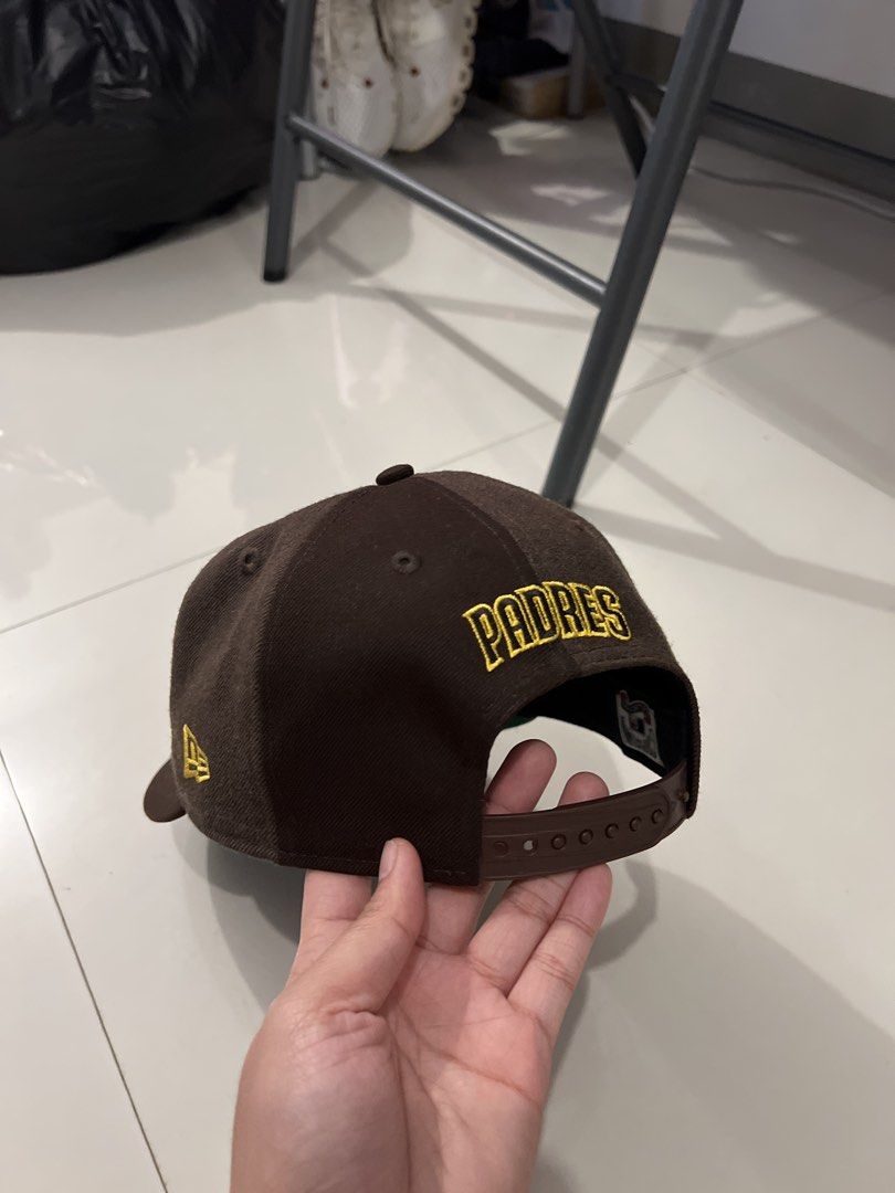 New Era San Diego Padres Cap (Category: Caps & Hats) located in Baguio. Submitted by rhyac (Listing ID 1423302109, Image 2). Description: - San Diego Padres cap - Features team logo on the front - "Padres" embroidered on the back - Brown color scheme with yellow accents - Curved brim - Snapback closure - New Era logo visible.