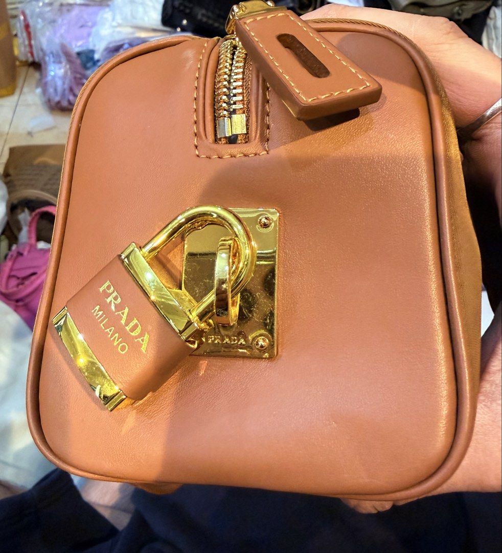 Prada Brown Nylon Handbag (Category: Luxury Bags & Wallets) located in Manila. Submitted by thebodega88 (Listing ID 1423314601, Image 3). Description: - Prada handbag - Brown nylon exterior - Gold-tone hardware - 'riri' zipper - Interior Prada logo - 'ECONYLO 100% REGENERATED NYLON' tag - Includes tag with number '165' NO ISSUE .