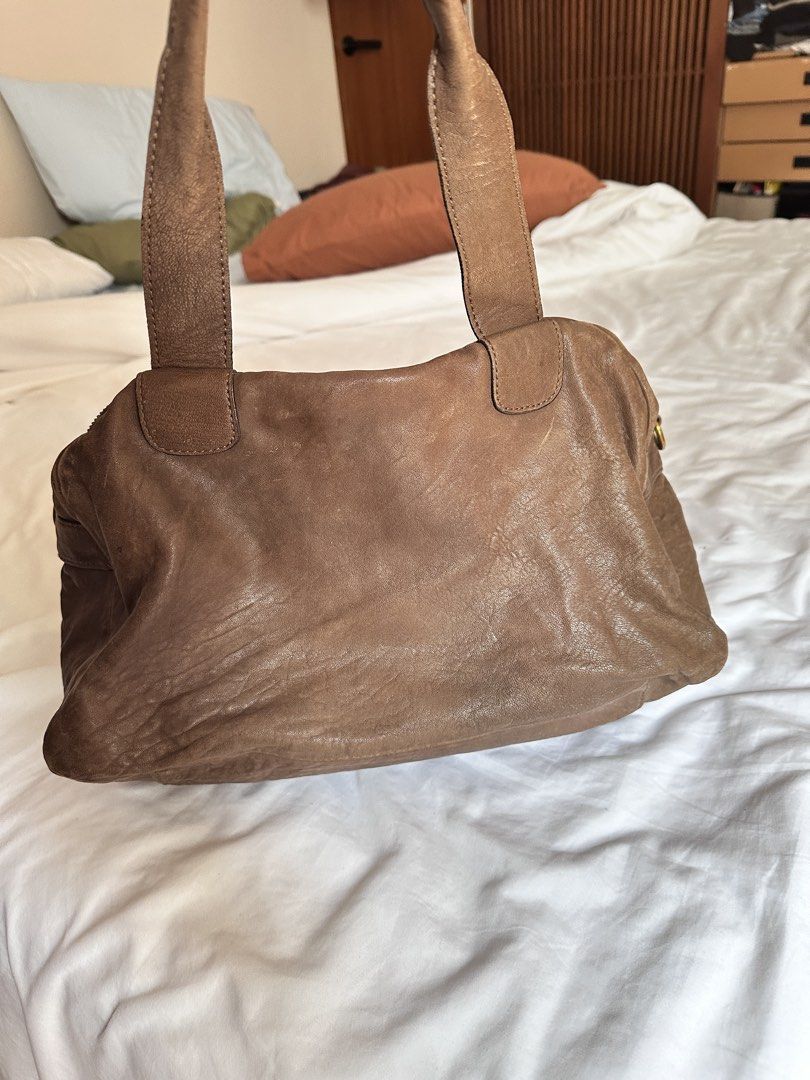 Rabeanco Genuine Leather Handbag (Category: Shoulder Bags) located in Tabuk. Submitted by classicseconds (Listing ID 1423270267, Image 3). Description: - rabeanco genuine leather handbag - Brown exterior - Zip closure - Two handles - Purple fabric lining - Interior zip pocket - Front pocket - Gold-tone hardware - "Genuine Leather" tag.