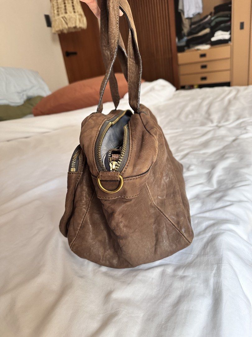Rabeanco Genuine Leather Handbag (Category: Shoulder Bags) located in Tabuk. Submitted by classicseconds (Listing ID 1423270267, Image 2). Description: - rabeanco genuine leather handbag - Brown exterior - Zip closure - Two handles - Purple fabric lining - Interior zip pocket - Front pocket - Gold-tone hardware - "Genuine Leather" tag.