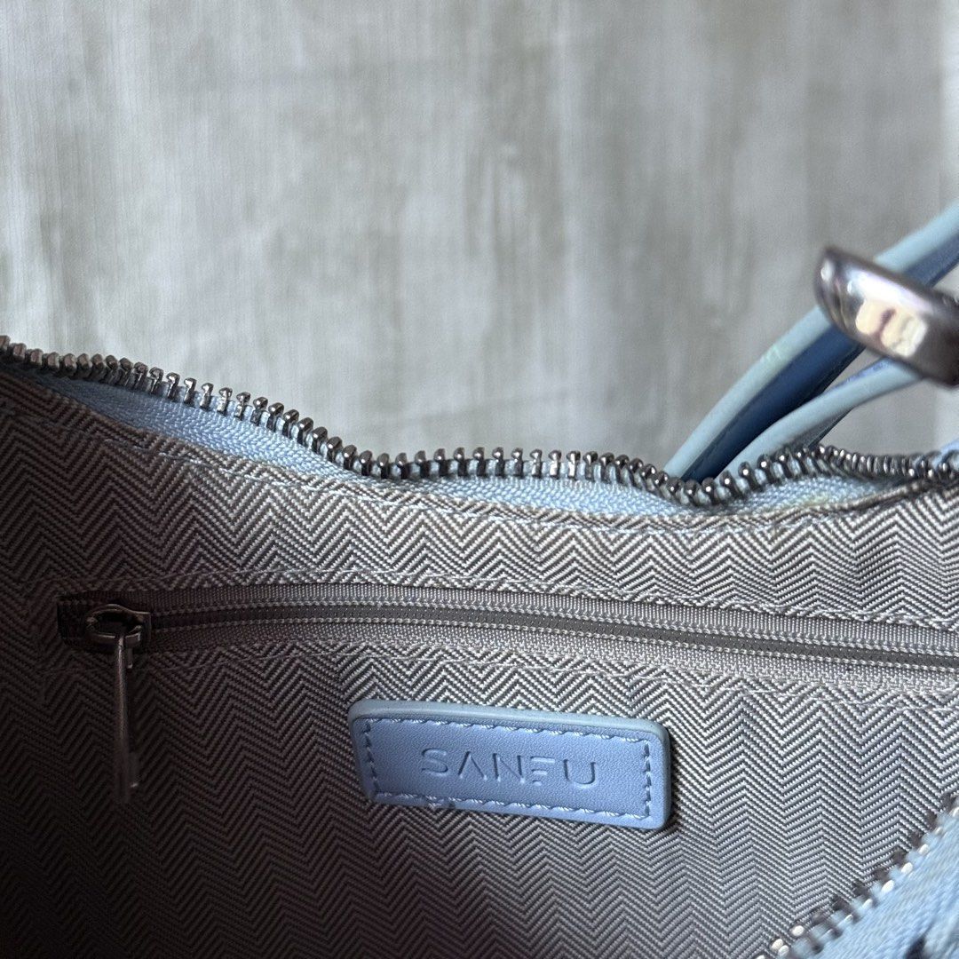 Sanfu Butter Shoulder Bag (Category: Shoulder Bags) located in Dagupan City. Submitted by hangoverph (Listing ID 1423319204, Image 3). Description: - Light blue shoulder bag with white trim - Features "BUTTER" embroidery on the front - Includes a "SANFU" brand tag - Silver zipper closure - Adjustable shoulder strap - Chic and ideal for daily use - Once used - Brand: Sanfu - RFS: decluttering.