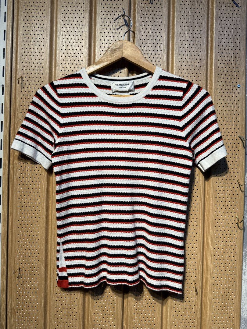Thom Browne Striped Knit Top (Category: Luxury Apparel) located in Santiago. Submitted by twicebutnice03 (Listing ID 1423336439, Image 1). Description: - Authentic Thom Browne knit top - Classic striped design (white, red, black) - Made in Scotland - Crew neck, short sleeves - Size S - Signature Thom Browne stripe detail at back of neck - 100% cotton.