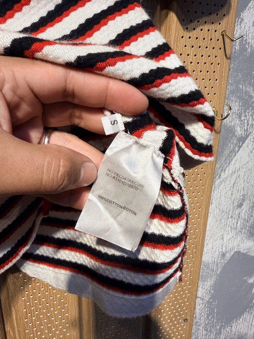 Thom Browne Striped Knit Top (Category: Luxury Apparel) located in Santiago. Submitted by twicebutnice03 (Listing ID 1423336439, Image 3). Description: - Authentic Thom Browne knit top - Classic striped design (white, red, black) - Made in Scotland - Crew neck, short sleeves - Size S - Signature Thom Browne stripe detail at back of neck - 100% cotton.