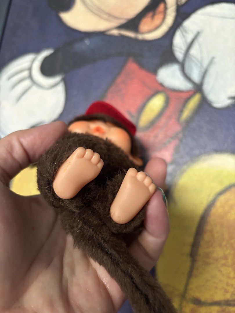 Vintage Monchhichi Plush Toy (Category: Plushies & Soft Toys) located in Quezon City. Submitted by coramalabanan (Listing ID 1423268831, Image 3). Description: - Adorable vintage Monchhichi plush toy - Features a brown fur body - Comes with a red headband - Smiling face - Plastic feet and face - Long brown tail - Includes original tag - A classic collectible item.
