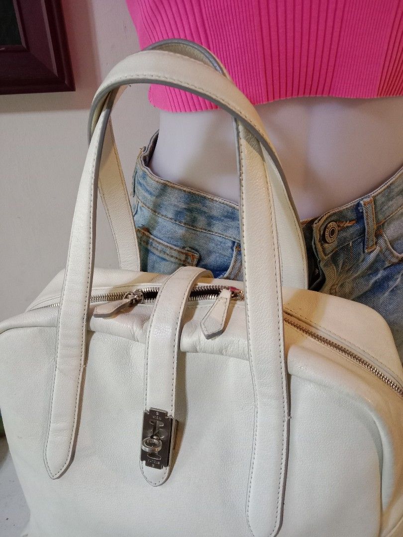 Vunque White toque ver. Leather Handbag (Category: Luxury Bags & Wallets) located in Davao. Submitted by hwagmahiyangtumawad (Listing ID 1423280420, Image 2). Description: Elegant Vunque handbag in white 100% natural cow leather. Features a top handle design with a secure clasp closure. The interior reveals a soft, light purple lining. Includes a zipper closure and a Vunque label inside. The bag has a rectangular shape with a structured design..