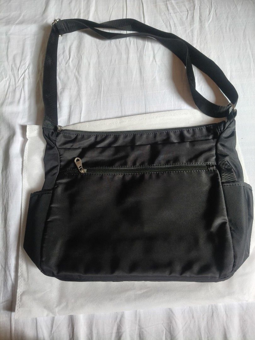 Black Sling Bag with Multiple Pockets (Category: Shoulder Bags) located in Navotas City. Submitted by olx_002 (Listing ID 1423471470, Image 2). Description: - Black shoulder bag - Main compartment with zipper - Interior pocket - Two front zipper pockets - Two side pockets - Adjustable shoulder strap - Smooth, possibly nylon material.
