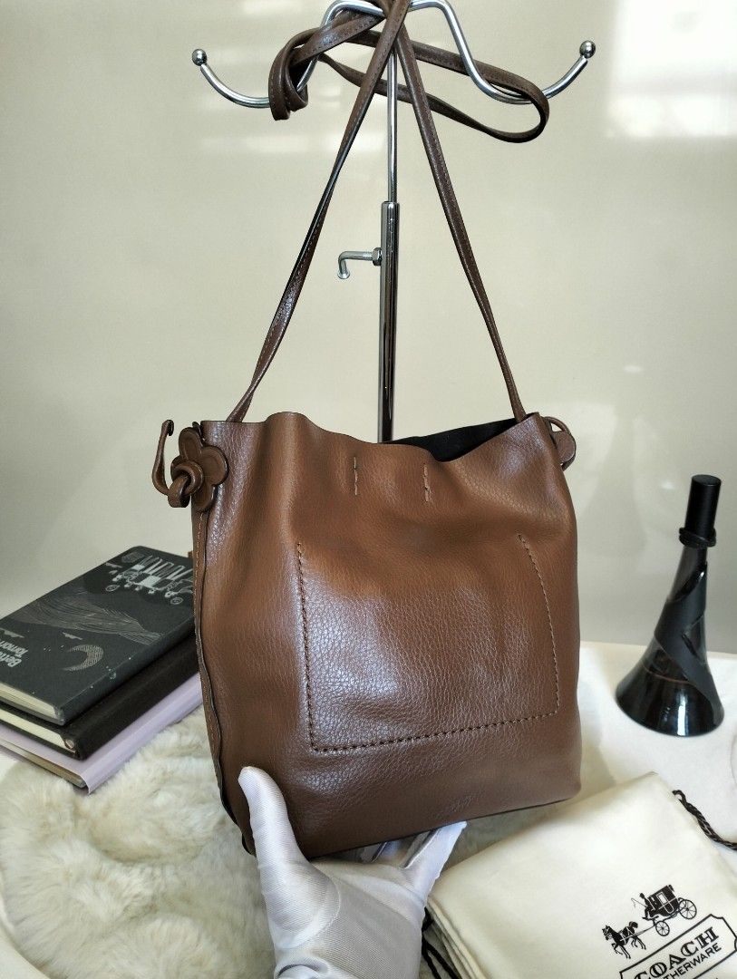 Coach Leather Choco Brown Bucket Bag (Category: Luxury Bags & Wallets) located in Manila. Submitted by alayassulittipidfinds (Listing ID 1423566194, Image 2). Description: - Authentic Coach bucket bag - Color: Brown - Material: Leather - Features: Shoulder strap, drawstring closure, interior pocket - Includes: Dust bag, Coach card - Design: Coach logo on front, black interior lining.