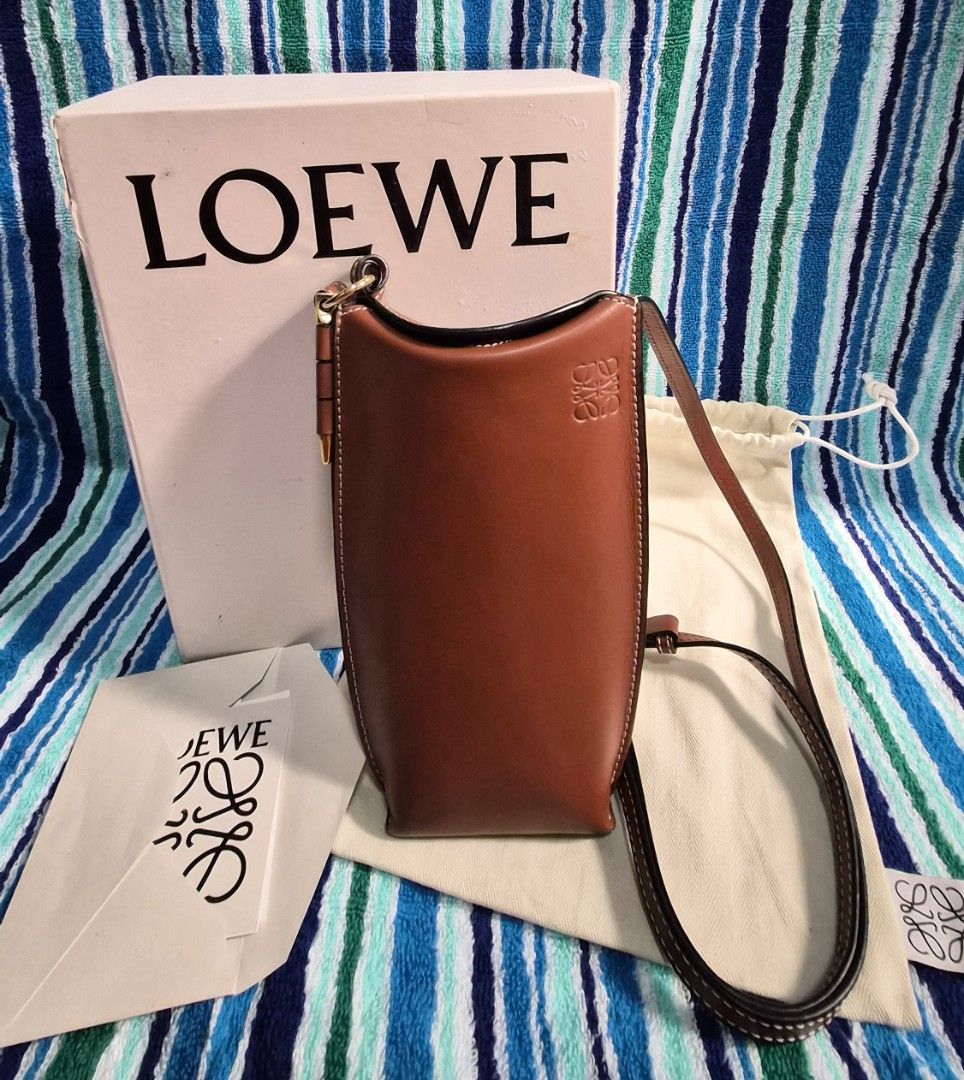 Loewe Leather Phone Bag (Gate Pocket) (Category: Luxury Bags & Wallets) located in Quezon City. Submitted by marya_s (Listing ID 1423459303, Image 1). Description: inclusions: box dustbag paper from Loewe and Receipt (japan bought) Loewe leather phone bag in a beautiful brown color. Features a detachable strap, interior card slot, and a soft interior lining. Comes with original box, dust bag, and tags. The bag has white stitching details and gold
