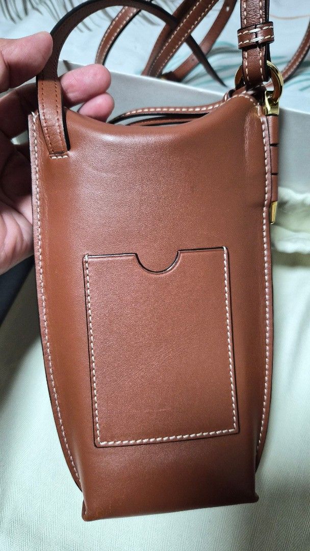 Loewe Leather Phone Bag (Gate Pocket) (Category: Luxury Bags & Wallets) located in Quezon City. Submitted by marya_s (Listing ID 1423459303, Image 3). Description: inclusions: box dustbag paper from Loewe and Receipt (japan bought) Loewe leather phone bag in a beautiful brown color. Features a detachable strap, interior card slot, and a soft interior lining. Comes with original box, dust bag, and tags. The bag has white stitching details and gold